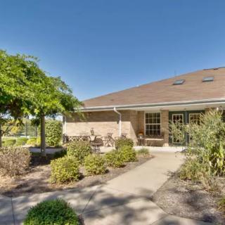 A sunny view of a house with a well-maintained garden and pathway.