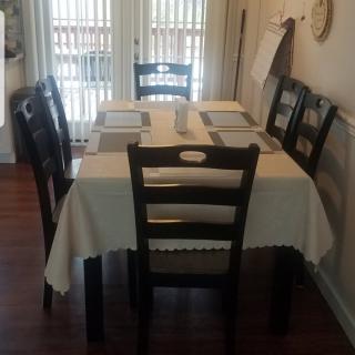 A neatly set dining table with six chairs in a cozy dining area.