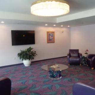 A modern waiting area with comfortable seating, a flat-screen TV, and decorative elements.