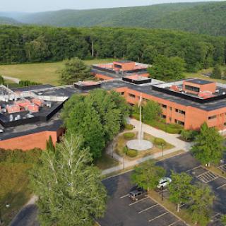 Aerial view of an educational campus surrounded by trees and open space.