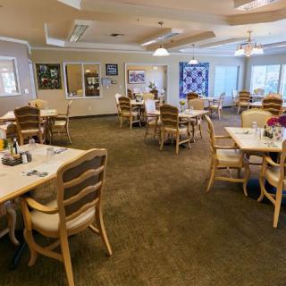 An empty dining room with neatly arranged tables and chairs, ready for guests.