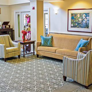 A cozy living room seating area with a sofa, chairs, and decorative elements.
