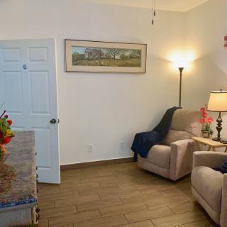 A cozy living room with armchairs, a lamp, and wall decor.