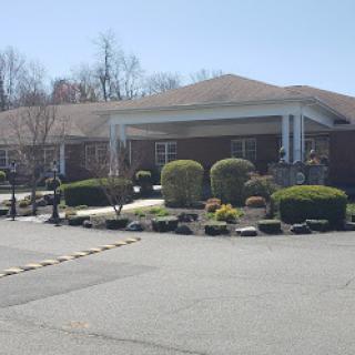 A well-maintained residential building with landscaped gardens under clear skies.