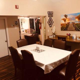 A cozy dining room setup with a table, surrounded by chairs and decorated with artwork on the wall.