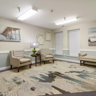 A modern waiting room with comfortable seating and decorative artwork.