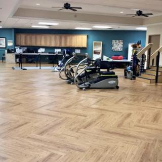 A spacious gym featuring exercise equipment including treadmills, with a wooden floor and modern decor.