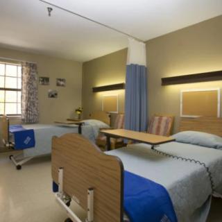 A shared hospital room with two beds and a window.