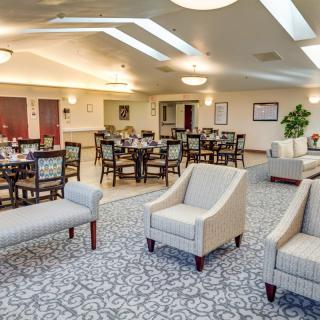 A spacious dining area with neatly arranged tables, chairs, and comfortable seating.