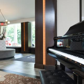 A modern living room with a grand piano and stylish decor.