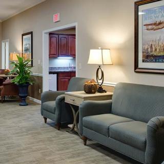 A cozy waiting room with comfortable seating, decorative lamps, and artwork on the walls.