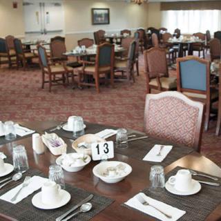 A dining room with neatly set tables and chairs, prepared for guests.