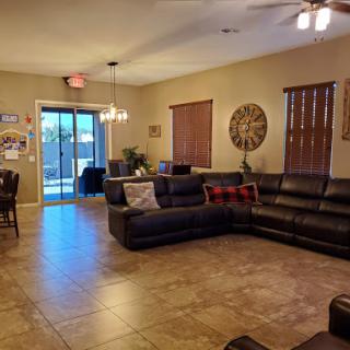 A spacious living room featuring a comfortable sectional sofa, warm lighting, and an inviting dining area.