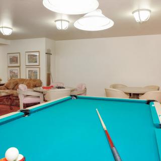 A cozy game room featuring a pool table and comfortable seating area.