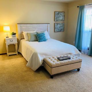 A cozy bedroom with a neatly made bed, soft lighting, and tasteful decor.