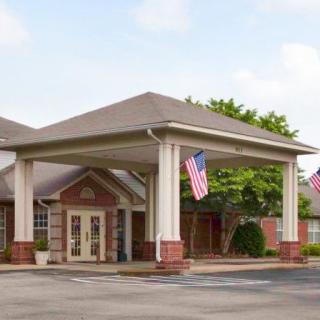 An entrance with a covered patio and American flags displayed.