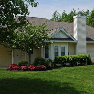 A charming suburban house with a well-maintained garden and lush green lawn.