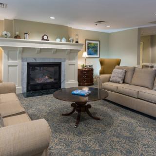 A cozy living room with comfortable seating, featuring a fireplace and elegant decor.