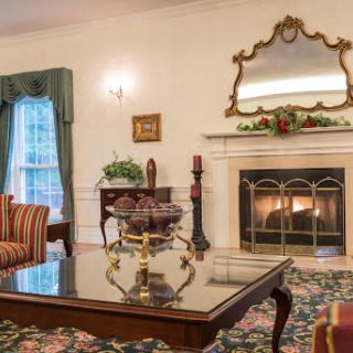 A beautifully decorated living room featuring a warm fireplace and elegant furnishings, creating a cozy and inviting atmosphere.