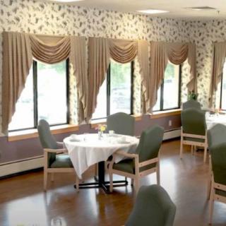 A cozy dining room with elegantly draped curtains and neatly arranged tables and chairs.