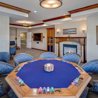 A luxurious game room featuring a poker table with chips and comfortable seating.