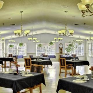 A spacious dining area with elegantly set tables and chandeliers.