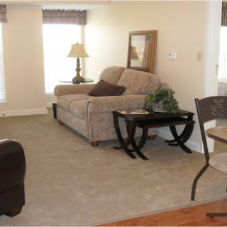 A cozy living room featuring a comfortable sofa, a side table, and warm lighting.