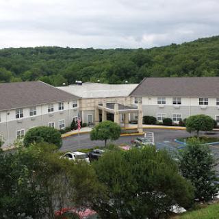 A view of a hotel surrounded by greenery and hills.