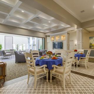 A modern dining and living area with elegant furnishings and blue table settings.