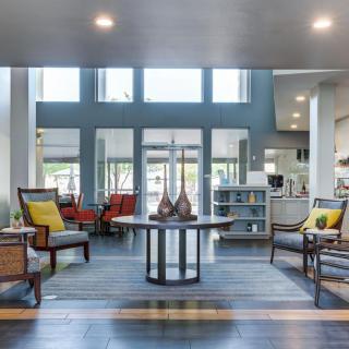 A spacious and modern living room with large windows and stylish furniture.
