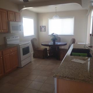 A cozy kitchen with a dining area featuring a small table and chairs, alongside a stove and countertop.
