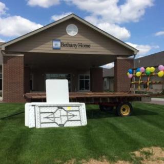 An outdoor event setup with tables and balloons in front of a building.