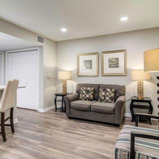 A modern living room with a comfortable sofa, decorative lamps, and artwork on the wall.