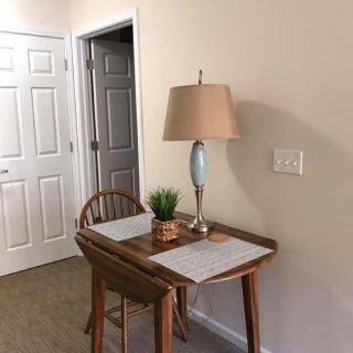 A cozy corner with a small desk, lamp, and chair.