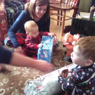 A joyful family moment as children excitedly open gifts during a holiday celebration.