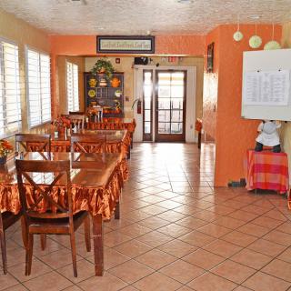 A cozy restaurant dining area with orange walls and neatly arranged tables and chairs.