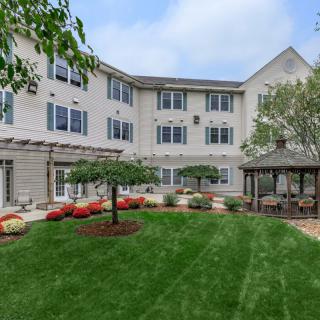 A peaceful residential garden with a gazebo and manicured lawn.