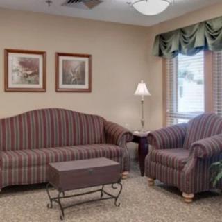 A cozy living room with a striped sofa, armchair, and a small coffee table.