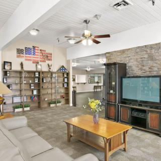 A cozy living room with a comfortable sofa, coffee table, television, and bookshelves adorned with various decor items.