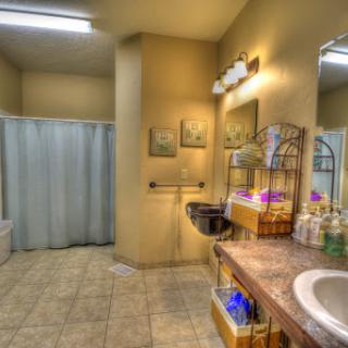 A well-lit and organized bathroom featuring a sink, shower curtain, and decorative items.