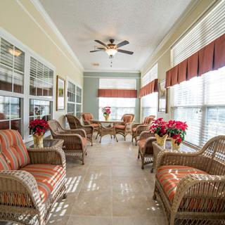 A bright and cozy sunroom featuring wicker furniture and abundant natural light.