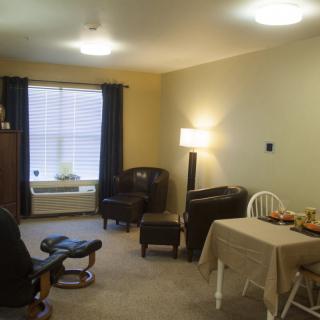 A cozy living room with comfortable seating, a table, and soft lighting.