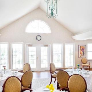A bright dining room with elegantly set tables and large windows.