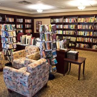 A cozy library reading area with bookshelves and comfortable armchairs.