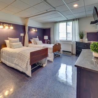 A modern hospital room featuring two neatly arranged beds and bright, welcoming decor.