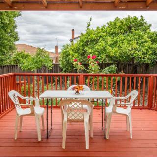 A cozy backyard deck with a table and chairs surrounded by greenery.