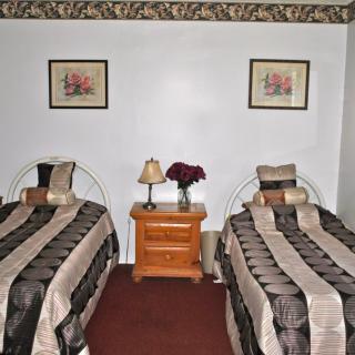 A cozy bedroom with twin beds, a nightstand, and decorative elements.