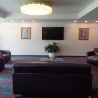 A modern lobby with comfortable seating, a television, and decorative artwork.