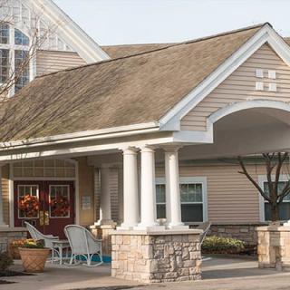 A welcoming entrance to a residential building featuring a porch with columns.