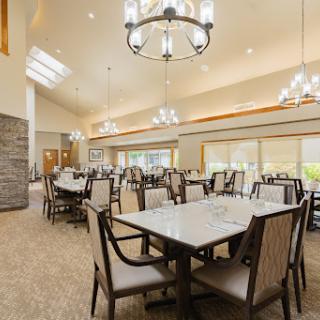 A spacious and elegantly designed dining area featuring modern furnishings and ample natural light.